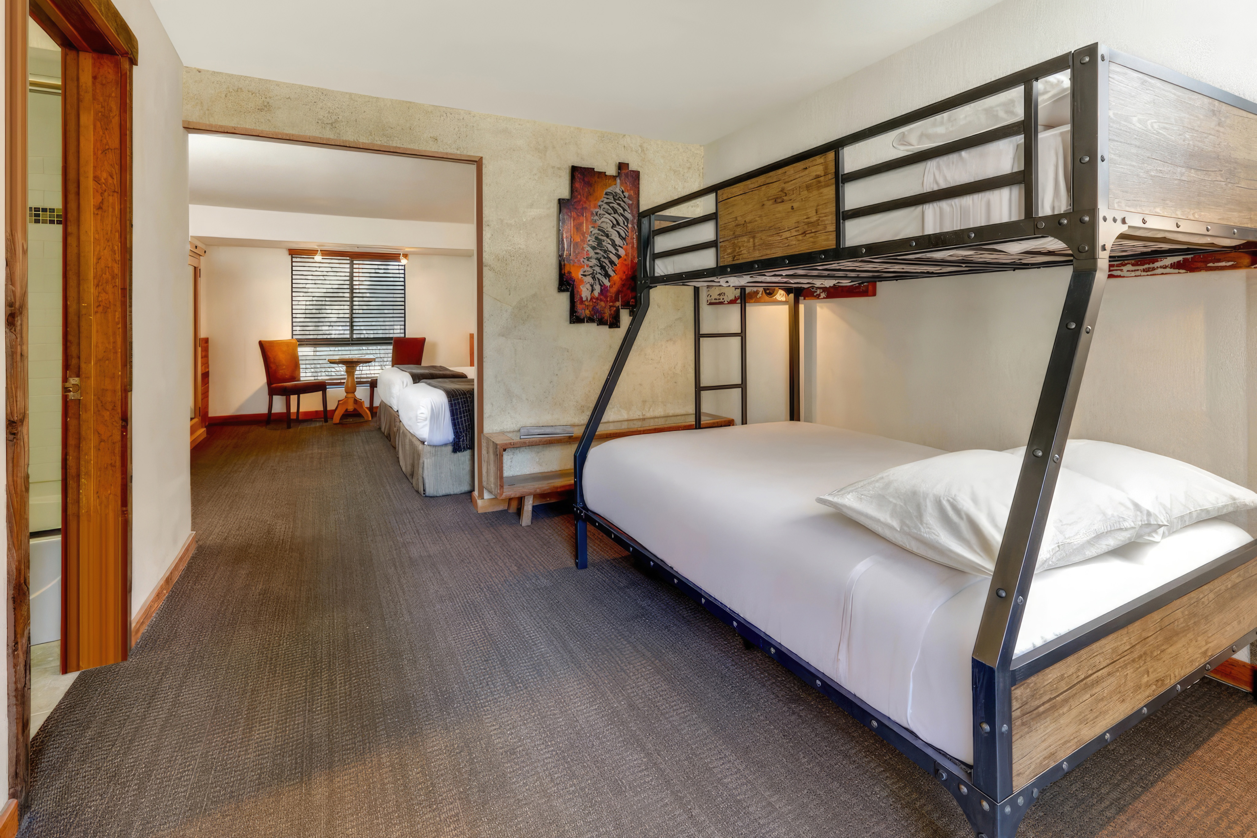 A room with a bunk bed and a doorway to another room.